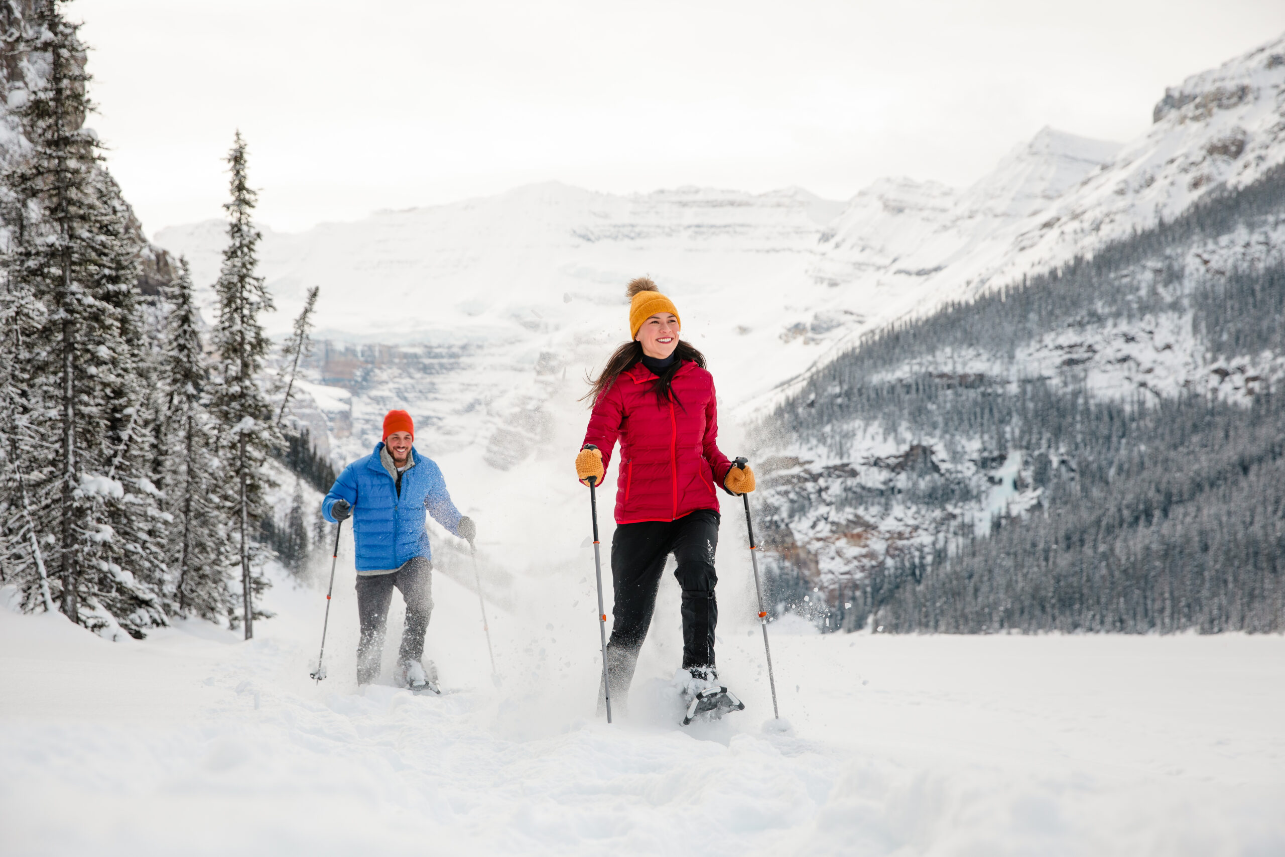 couple snowshoeing in snowy conditions at lake louise