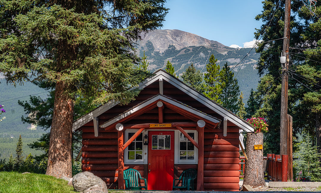 Red cabin with mountain backdrop